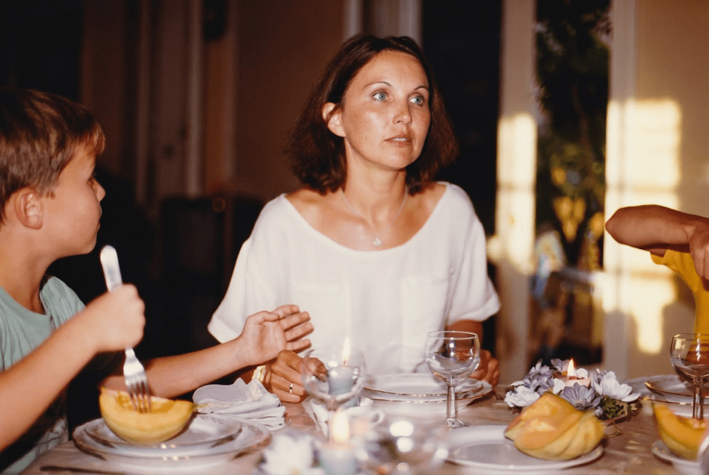 1983. Je revois cette table, la lumière douce, et Maman au centre. Vincent est à sa gauche, Nicolas à sa droite. Elle écoute, elle réfléchit, elle est déjà ailleurs et pourtant si présente. Son regard, profond, intense, éclaire la pièce — ses yeux verts captent tout, comme si chaque mot comptait. On devine un échange passionné, une discussion qui l’anime. À cet instant précis, elle est simplement elle : belle, attentive, habitée